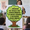 Professora segurando cartaz 2 Pedro 3:18 para Ministério Infantil